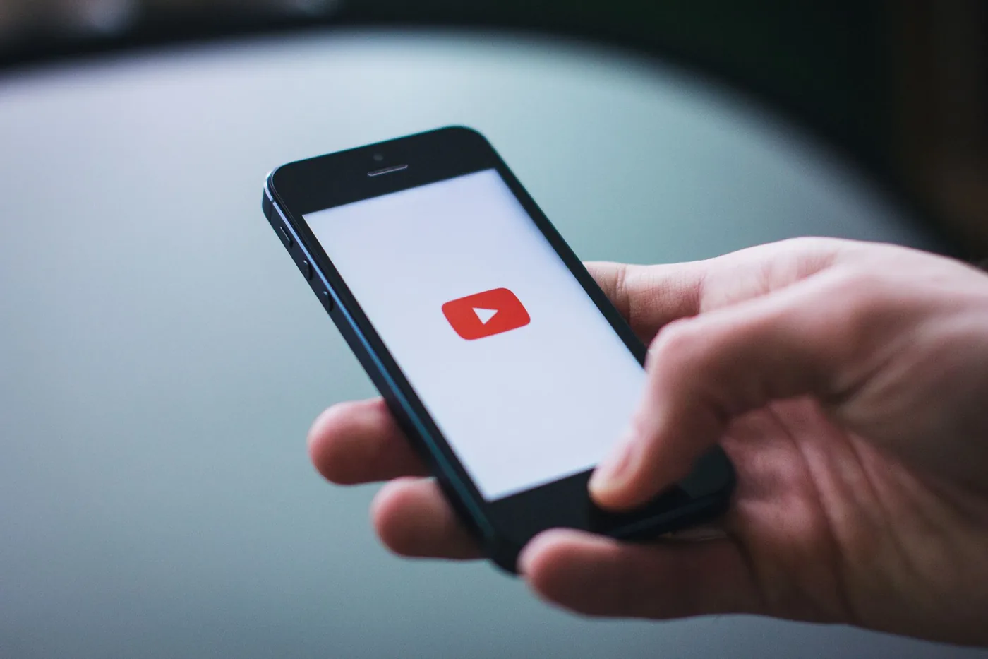 A smartphone displaying a YouTube video alongside a short branded link and click analytics dashboard